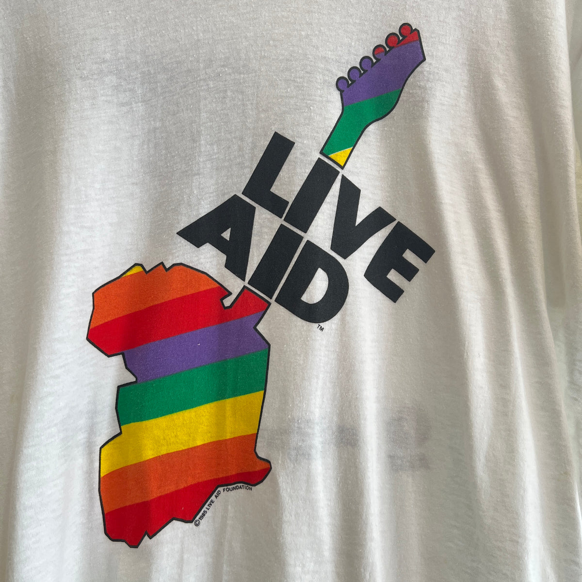 1985s Live Aid Logo T-Shirt with This Shirt Saves Lives Letters Print