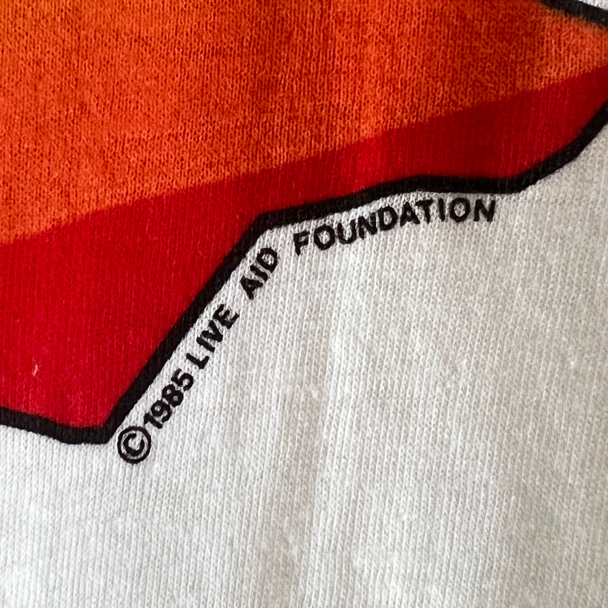 1985s Live Aid Logo T-Shirt with This Shirt Saves Lives Letters Print