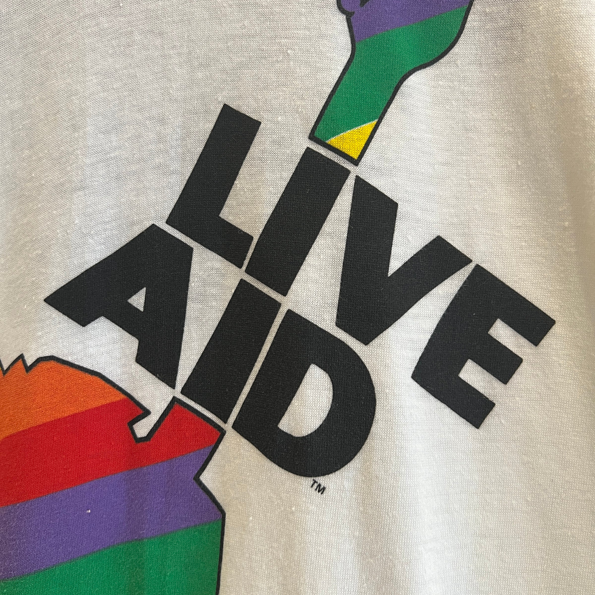 1985s Live Aid Logo T-Shirt with This Shirt Saves Lives Letters Print