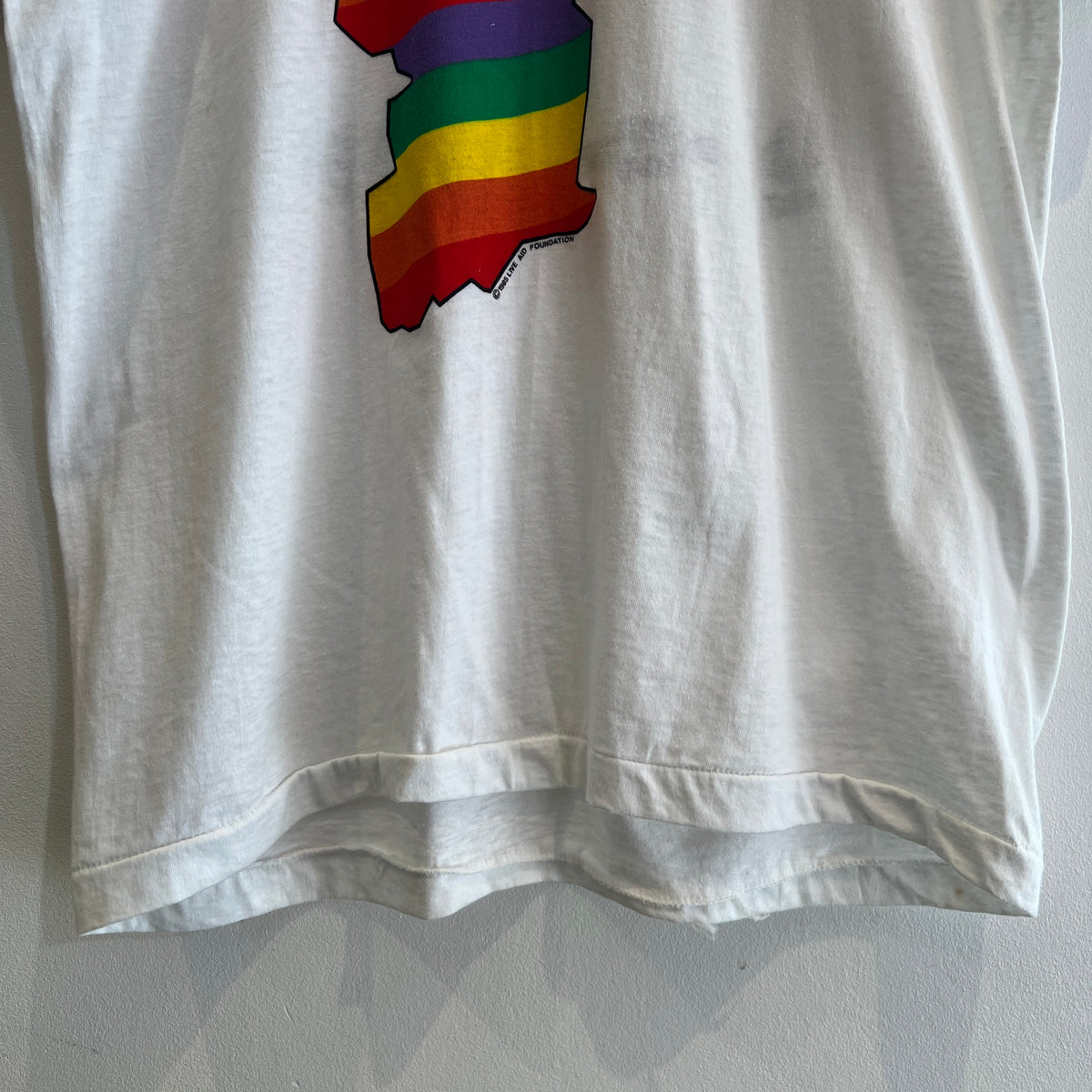 1985s Live Aid Logo T-Shirt with This Shirt Saves Lives Letters Print